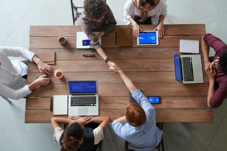 Photo of people sitting at a table on their laptops