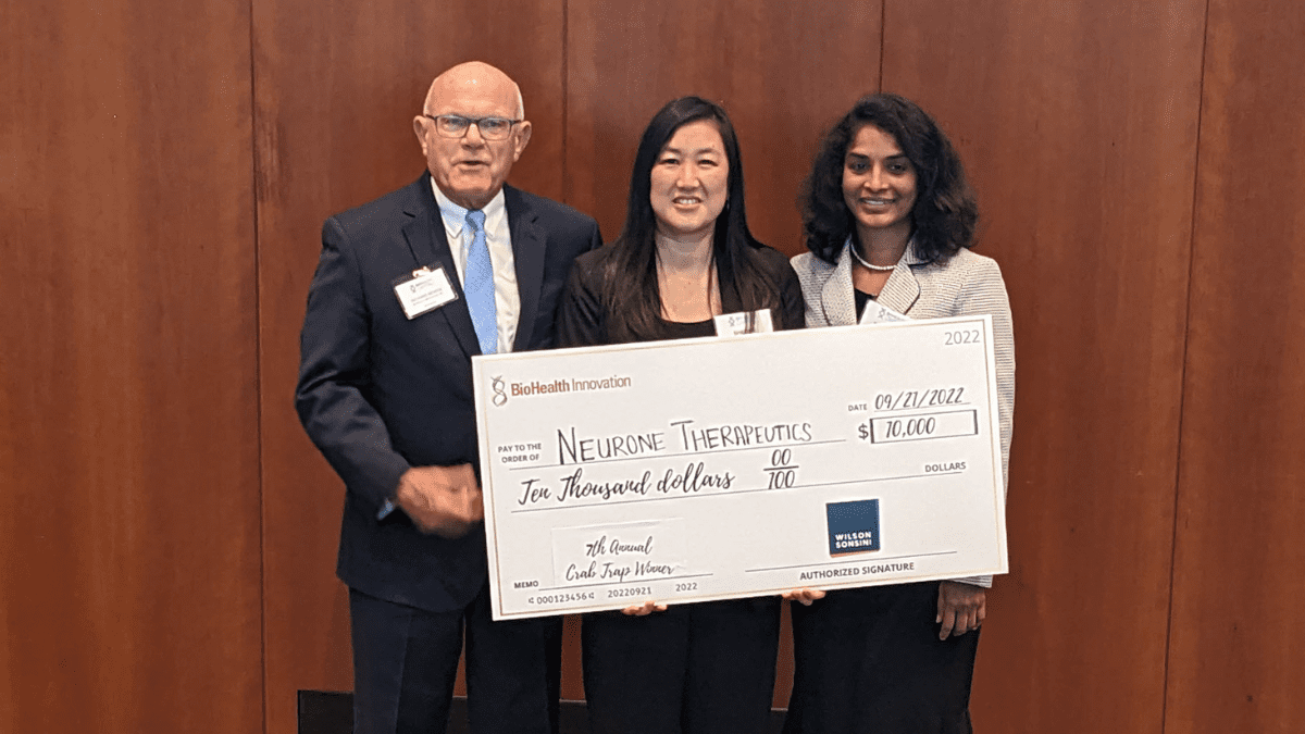 Neuroene Therapeutics standing with Rich Bendis of BioHealth Innovations, holding a giant check